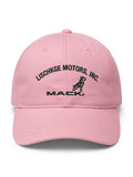 A light pink baseball cap featuring black embroidered text that reads 'LISCHKGE MOTORS, INC.' and 'MACK' with a dog logo, shown against a plain white background.